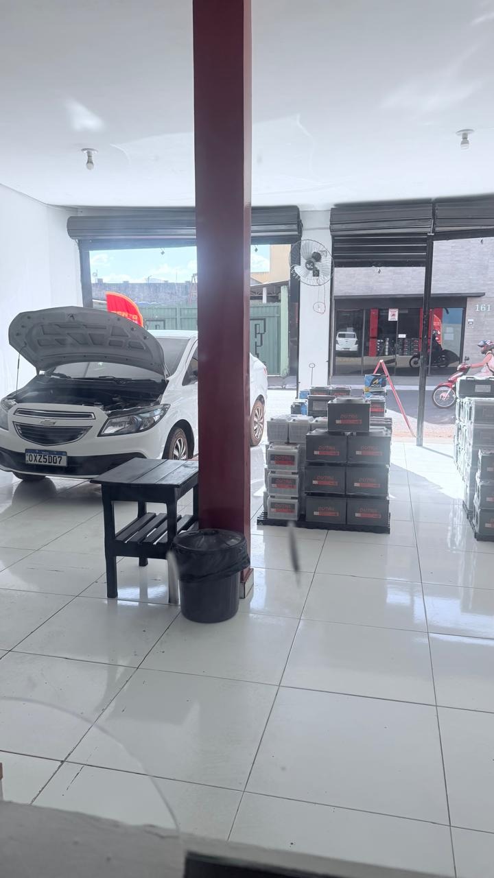 Interior da loja com carro e estoque de baterias
